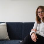Emotionale Verletzlichkeit Ursachen: Frau sitzt ruhig auf einem Sofa und wirkt offen, aber sensibel.